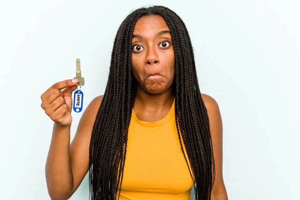 Mladá Afroameričanka Drží Domácí Klíče Izolované Modrém Pozadí Pokrčí Rameny — Stock fotografie