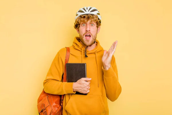Młody Student Człowiek Noszenie Kask Rower Odizolowany Żółtym Tle Zaskoczony — Zdjęcie stockowe