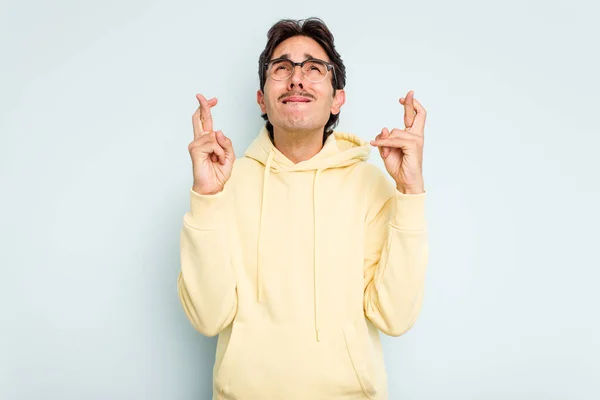 Young Hispanic Man Isolated Blue Background Crossing Fingers Having Luck — стоковое фото