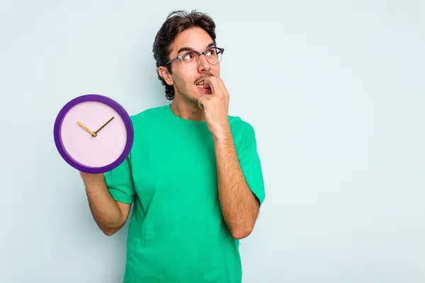 Jovem Hispânico Segurando Relógio Isolado Fundo Branco Relaxado Pensando Algo — Fotografia de Stock