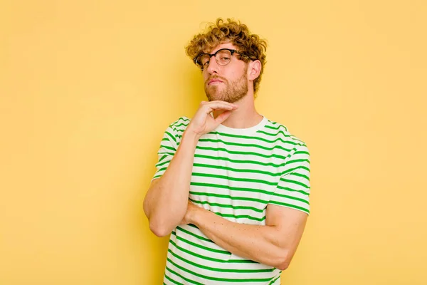 Young Caucasian Man Isolated Yellow Background Suspicious Uncertain Examining You — Stock Photo, Image