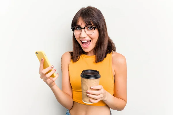 Młoda Kaukaska Kobieta Trzymająca Kawę Wynos Telefon Komórkowy Odizolowany Białym — Zdjęcie stockowe