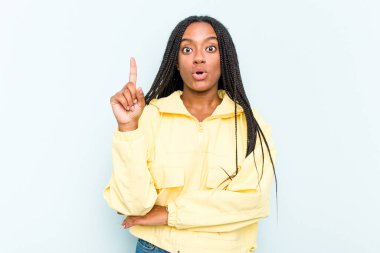 Mavi arka planda saç örgüsü olan genç Afrikalı Amerikalı bir kadının harika bir fikri var, yaratıcılık kavramı..