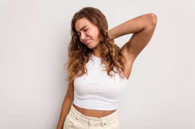 Genç beyaz kadın mavi arka planda izole edilmiş. Stres yüzünden boynu ağrıyor. Masaj yapıyor ve elle dokunuyor..