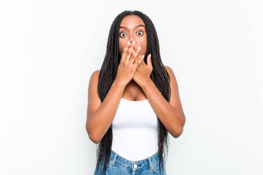 Beyaz arka planda izole edilmiş genç Afrikalı Amerikalı kadın şok olmuş, ağzı ellerle kaplanmış, yeni bir şey keşfetmeye hevesli..