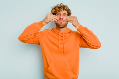 Kafkasyalı genç adam mavi arka planda izole edilmiş iki seçenek arasında şüphe duyuyor.