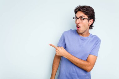 Genç İspanyol adam mavi arka planda izole edilmiş başparmak uzakta, gülüyor ve kaygısız.