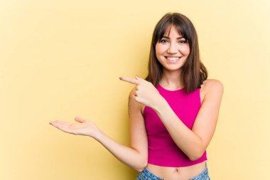 Sarı arka planda izole edilmiş beyaz bir kadın. Elinde palmiye ağacının fotokopisini tutarken heyecanlı..