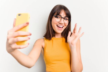 Beyaz arka planda izole edilmiş cep telefonu kullanan beyaz bir kadın.