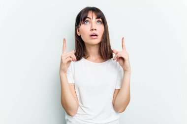 Beyaz arka planda izole edilmiş beyaz bir kadın ağzı açık bir şekilde üst tarafı işaret ediyor..