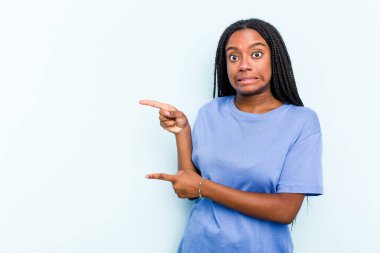 Mavi arka planda saç örgüsü olan genç Afrikalı Amerikalı kadın işaret parmağıyla fotokopi çekilen yeri işaret ederek şok oldu..