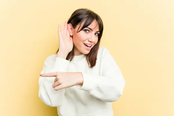 Giovane Donna Caucasica Isolata Sfondo Giallo Cercando Ascoltare Pettegolezzo — Foto Stock