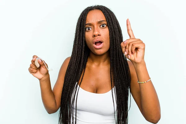 Ung Afroamerikansk Kvinna Håller Hörapparat Isolerad Blå Bakgrund Har Idé — Stockfoto