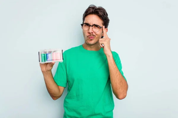 Ung Latinamerikansk Man Håller Batteribox Isolerad Vit Bakgrund Pekar Tempel — Stockfoto