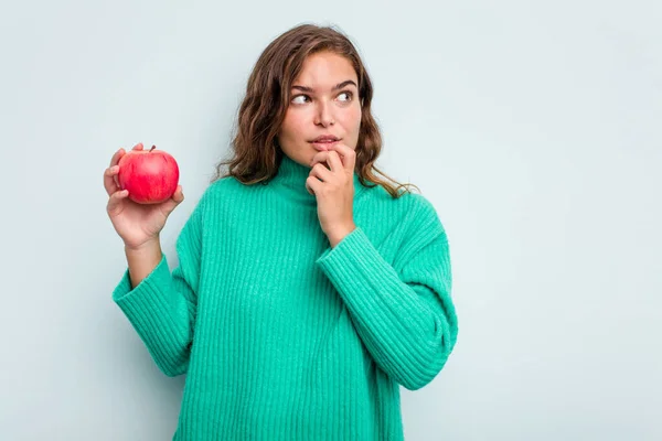 Junge Kaukasische Frau Mit Einem Auf Blauem Hintergrund Isolierten Apfel — Stockfoto