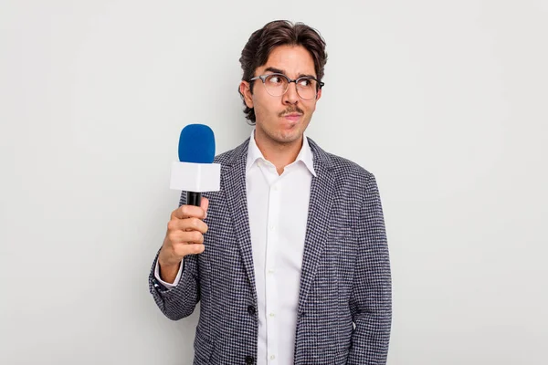 Mladý Hispánský Televizní Moderátor Muž Izolovaný Bílém Pozadí Zmatený Nedůvěřivý — Stock fotografie