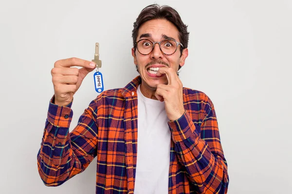 Junger Hispanischer Mann Mit Hausschlüssel Isoliert Auf Weißem Hintergrund Beißt — Stockfoto