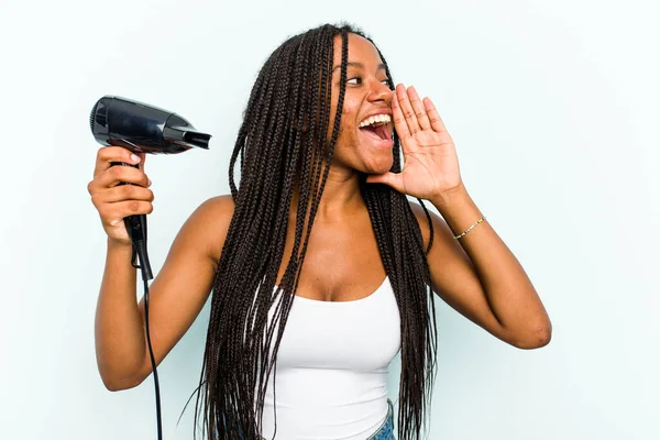 Young African American Woman Holding Hairdryer Isolated Blue Background Shouting — Stock Photo, Image