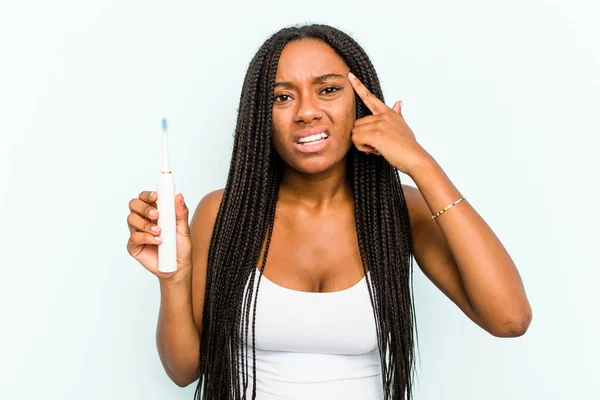 Ung Afroamerikansk Kvinna Håller Elektrisk Tandborste Isolerad Blå Bakgrund Visar — Stockfoto