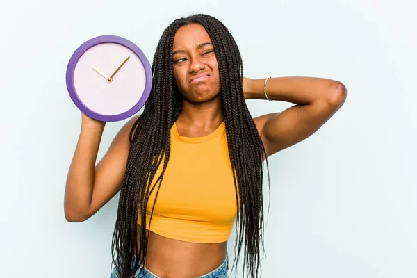 Young African American Woman Holding Clock Isolated Blue Background Touching — Stock Photo, Image