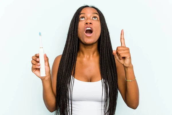 Młoda Afroamerykanka Trzymająca Elektryczną Szczoteczkę Zębów Odizolowana Niebieskim Tle Skierowana — Zdjęcie stockowe