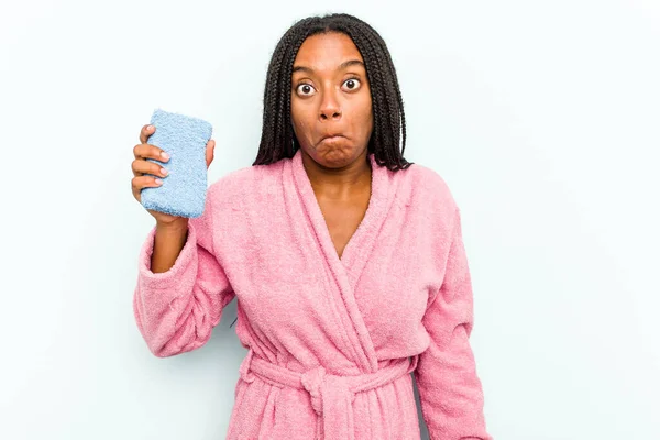 Ung Afroamerikansk Kvinna Håller Svamp Isolerad Blå Bakgrund Axelryckningar Axlar — Stockfoto