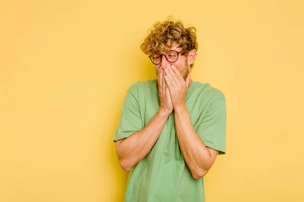 Jovem Caucasiano Isolado Fundo Amarelo Rindo Algo Cobrindo Boca Com — Fotografia de Stock