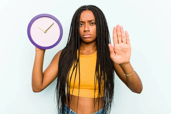 Ung Afroamerikansk Kvinna Håller Klocka Isolerad Blå Bakgrund Står Med — Stockfoto
