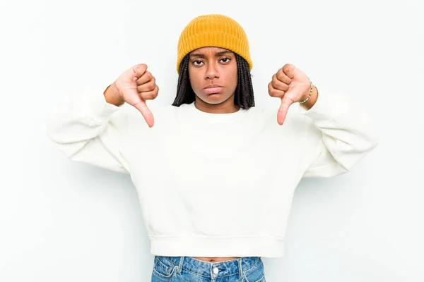 年轻的非洲裔美国妇女在白人背景下被隔离 表现出不喜欢的姿态 大拇指垂下 不同意的概念 — 图库照片