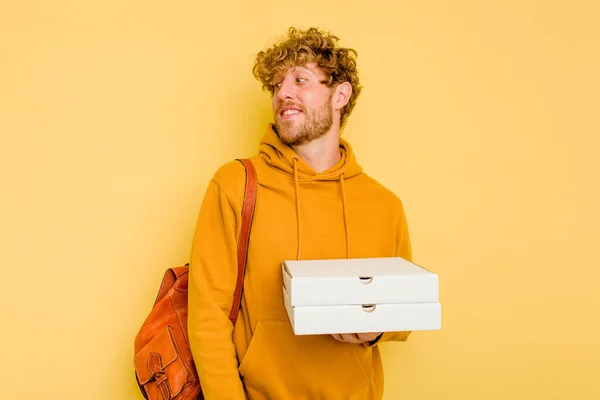 Młody Student Trzymający Pizzę Żółtym Tle Wygląda Uśmiechniętego Wesołego Miłego — Zdjęcie stockowe