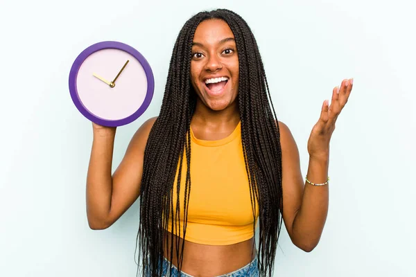 Young African American Woman Holding Clock Isolated Blue Background Receiving — Stock Photo, Image