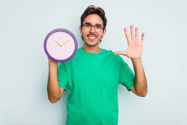 Jeune Homme Hispanique Tenant Une Horloge Isolée Sur Fond Blanc — Photo