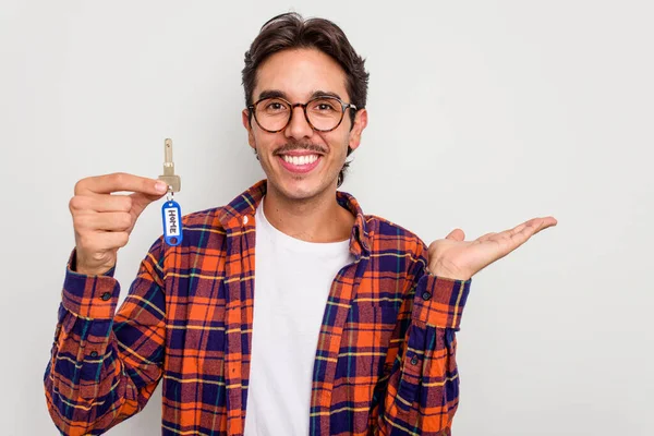 Mladý Hispánec Drží Doma Klíče Izolované Bílém Pozadí Zobrazující Kopírovací — Stock fotografie