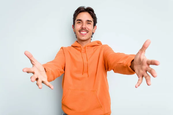 Young Hispanic Man Isolated Blue Background Showing Welcome Expression — стоковое фото