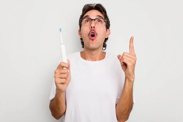 Jovem Hispânico Segurando Escova Dentes Elétrica Isolada Fundo Branco Apontando — Fotografia de Stock