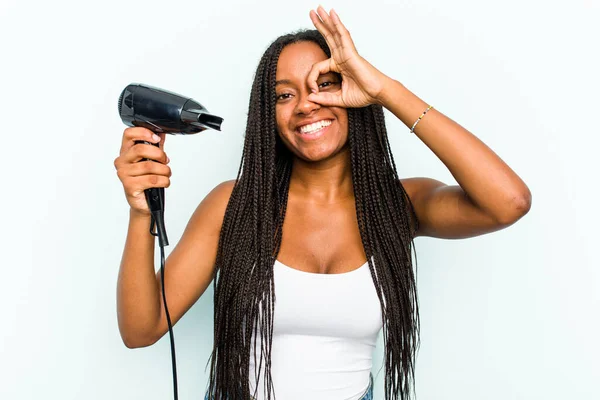 若いですアフリカ系アメリカ人女性を保持していますヘアドライヤー隔離上の青の背景励起キープOkジェスチャーオン目 — ストック写真
