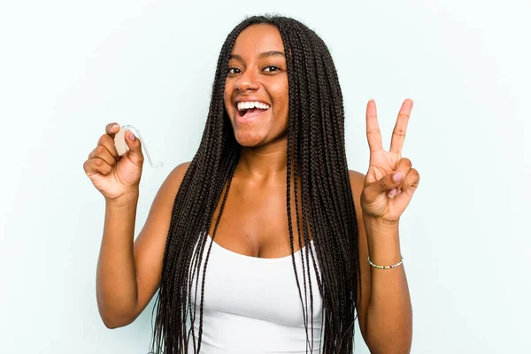 Elinde Işitme Cihazı Tutan Genç Afrikalı Kadın Mavi Arka Planda — Stok fotoğraf