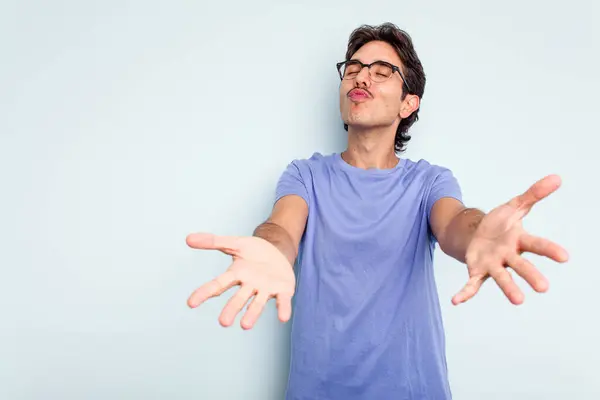 Joven Hispano Aislado Sobre Fondo Azul Doblando Labios Sosteniendo Palmas — Foto de Stock