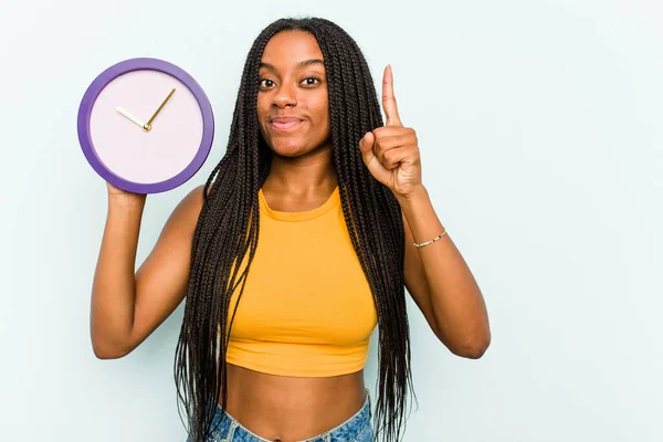 Ung Afroamerikansk Kvinna Håller Klocka Isolerad Blå Bakgrund Visar Nummer — Stockfoto
