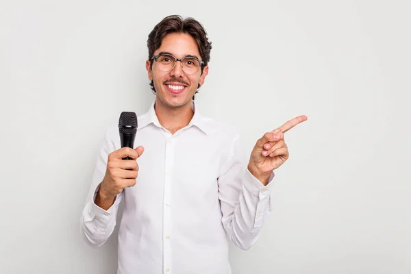 Joven Cantante Hispano Aislado Sobre Fondo Blanco Sonriendo Señalando Lado —  Fotos de Stock