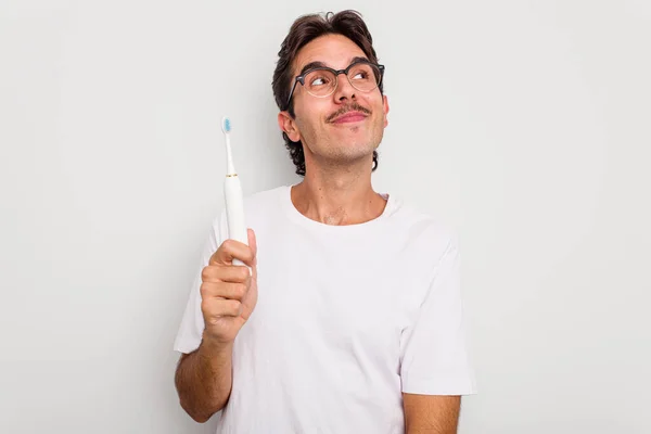 Jonge Spaanse Man Met Elektrische Tandenborstel Geïsoleerd Witte Achtergrond Dromen — Stockfoto