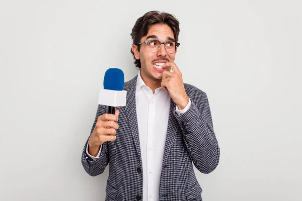 Mladý Hispánský Televizní Moderátor Muž Izolovaný Bílém Pozadí Kousání Nehty — Stock fotografie