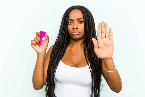 年轻的非洲裔美国女人拿着一只蓝色背景的月经杯 伸出的手显示出停止的迹象 阻止了你 — 图库照片