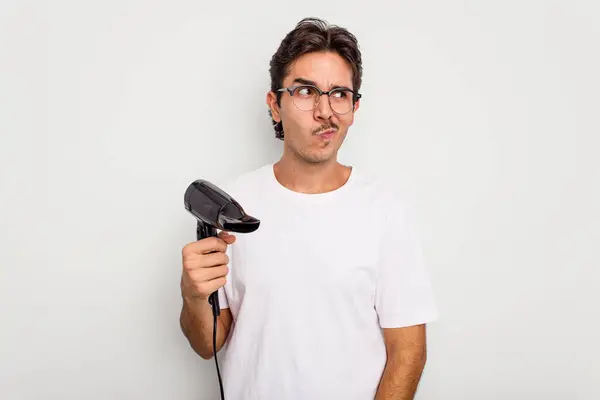 Jovem Hispânico Segurando Secador Cabelo Isolado Fundo Branco Confuso Sente — Fotografia de Stock