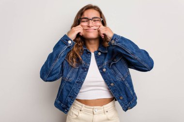 Kafkasyalı genç bir kadın mavi arka planda izole edilmiş. İki seçenek arasında şüpheli..