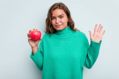 Mavi arka planda soyutlanmış beyaz bir kadın gülümseyerek beş numarayı parmaklarıyla gösteriyor..