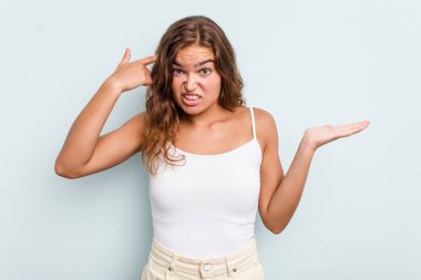 Beyaz bir kadın mavi arka planda izole edilmiş ve elinde bir ürün tutuyor..