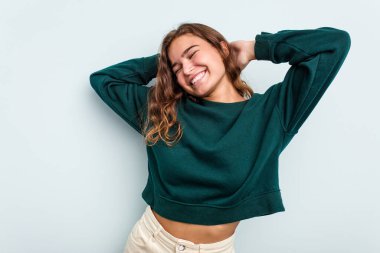 Mavi arka planda izole edilmiş genç beyaz kadın kollarını uzatıyordu, rahat bir pozisyondaydı..