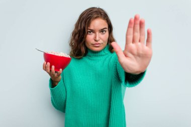 Mavi arka planda bir kase mısır gevreği tutan beyaz bir kadın elini uzatmış, dur işareti göstererek seni engelliyor..