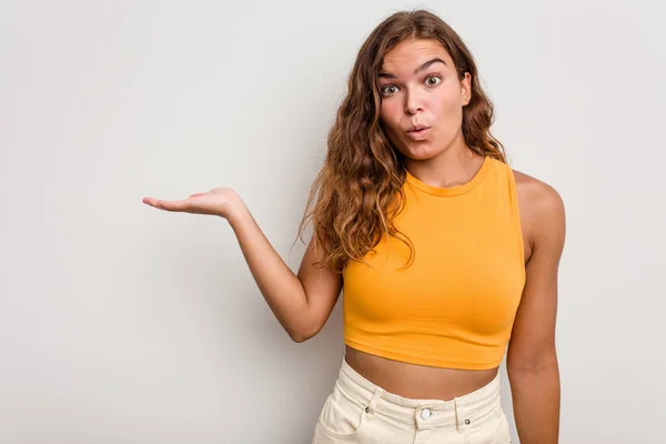 Jovem Mulher Caucasiana Isolado Fundo Azul Impressionado Segurando Espaço Cópia — Fotografia de Stock